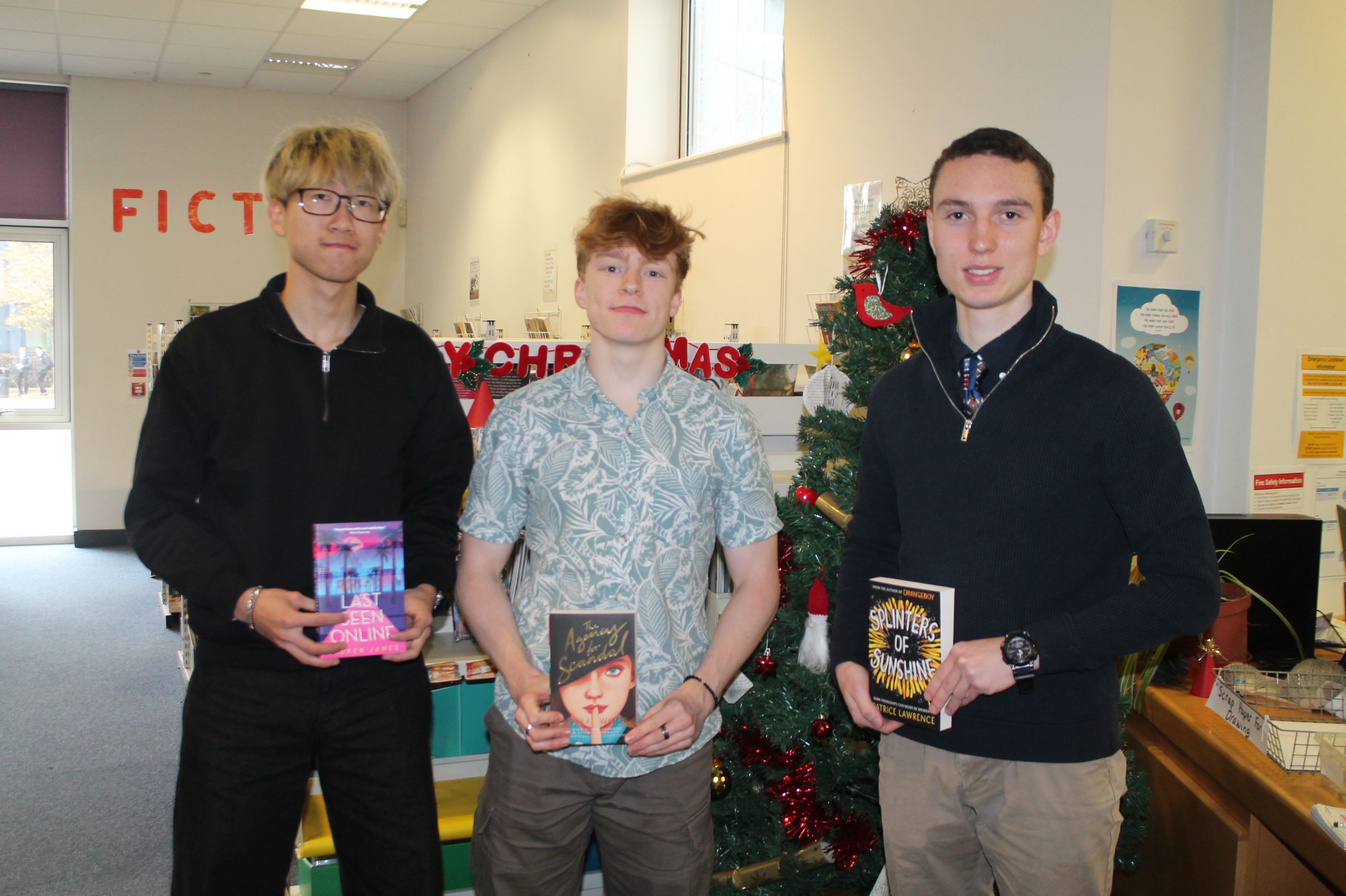 three students with their book prize as an advent literacy winner 