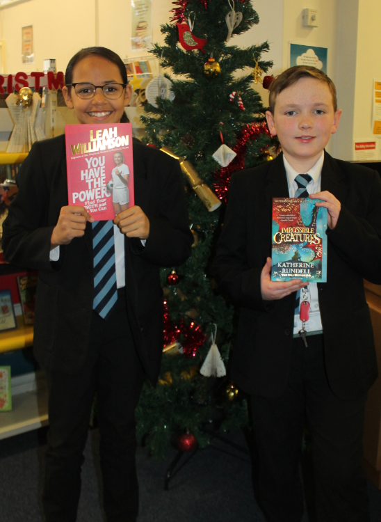 two students with their book prize as an advent literacy winner 