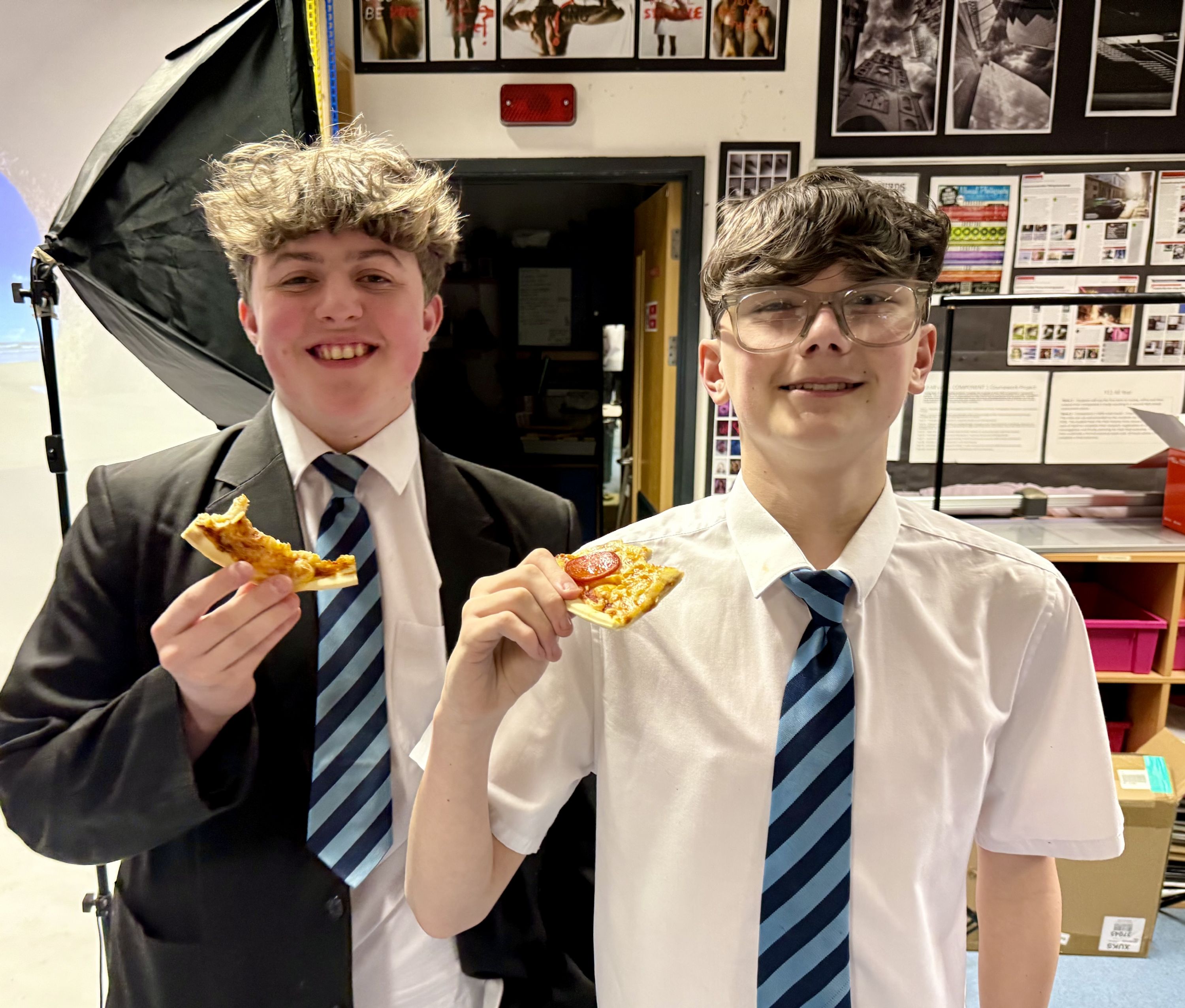 Two studnest enjoying a slice of poizza as a reward for attending the revision evening