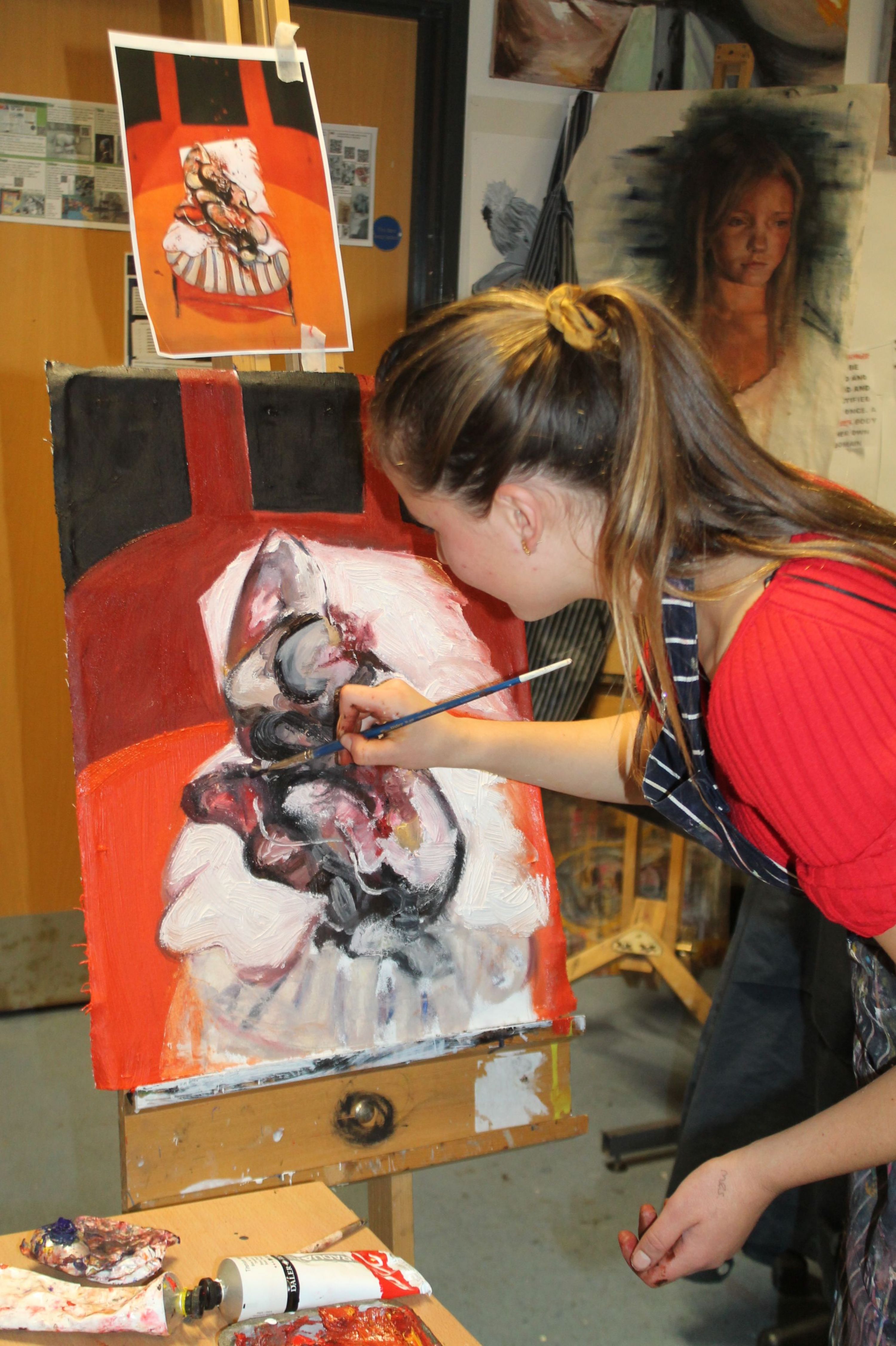 An A Level Art student painting at the Open Evening 