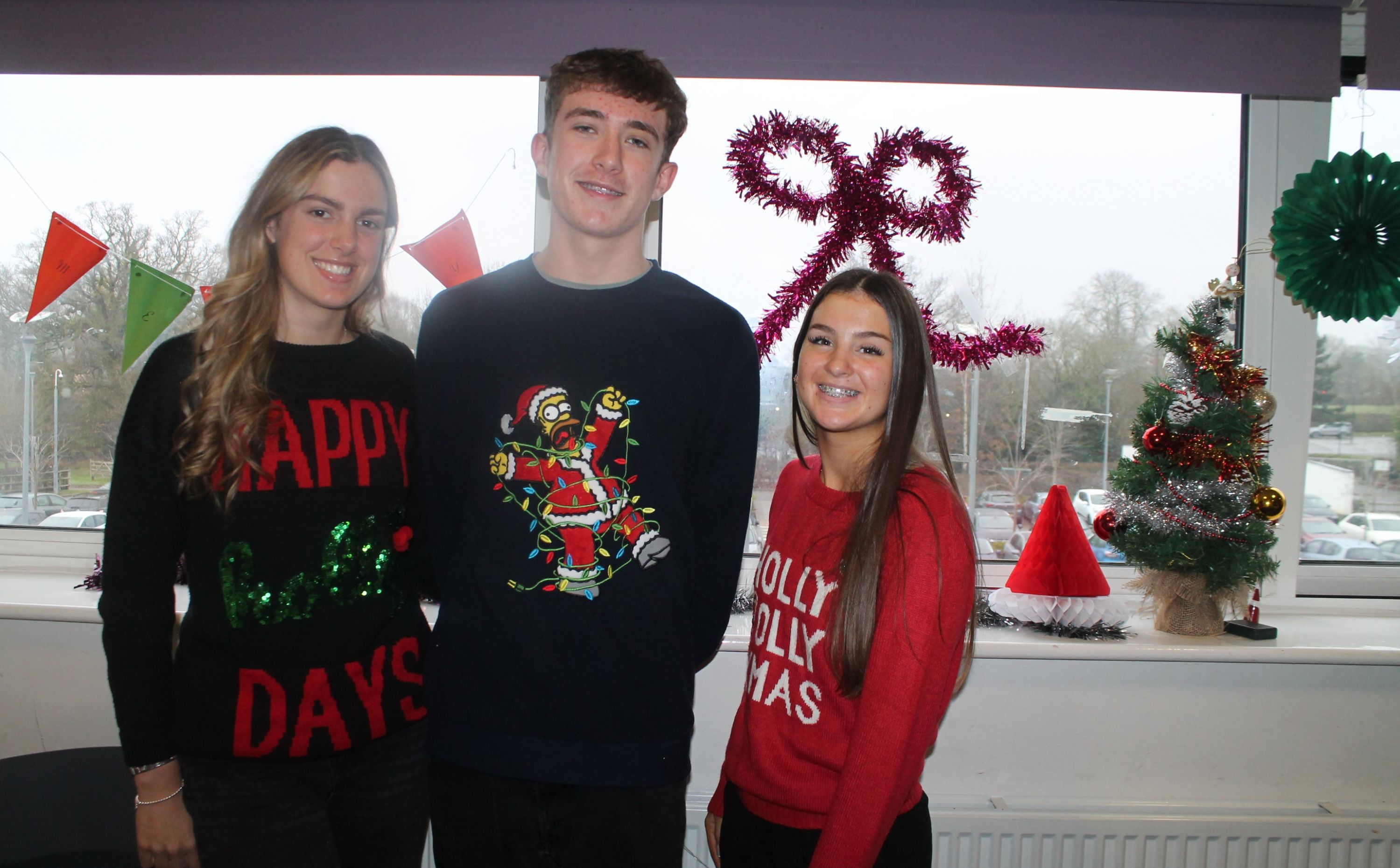 Three students wearing Christmas jumpers to raise money for Save the Children