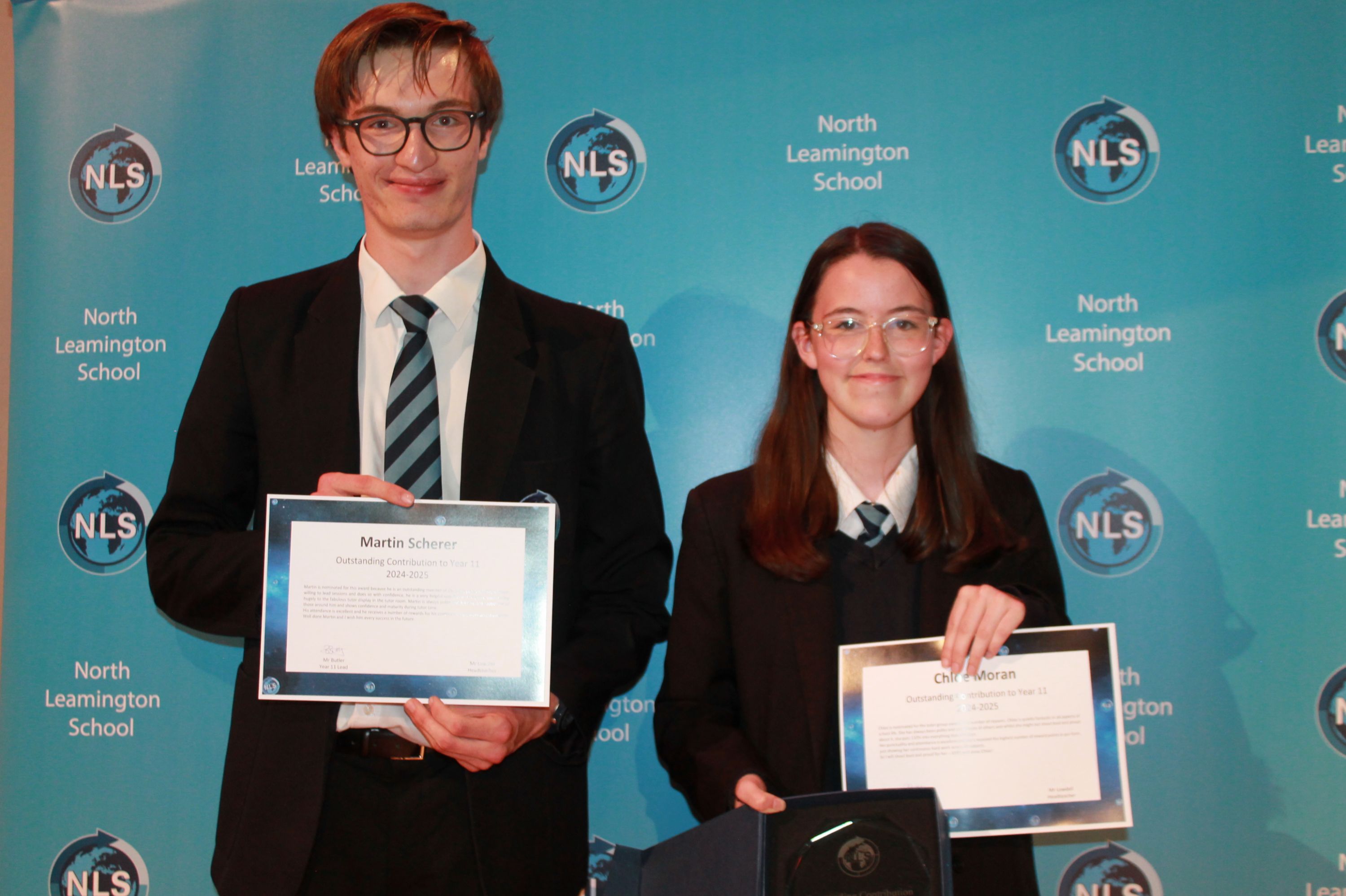 Two students at celebration evening with their certificate and award