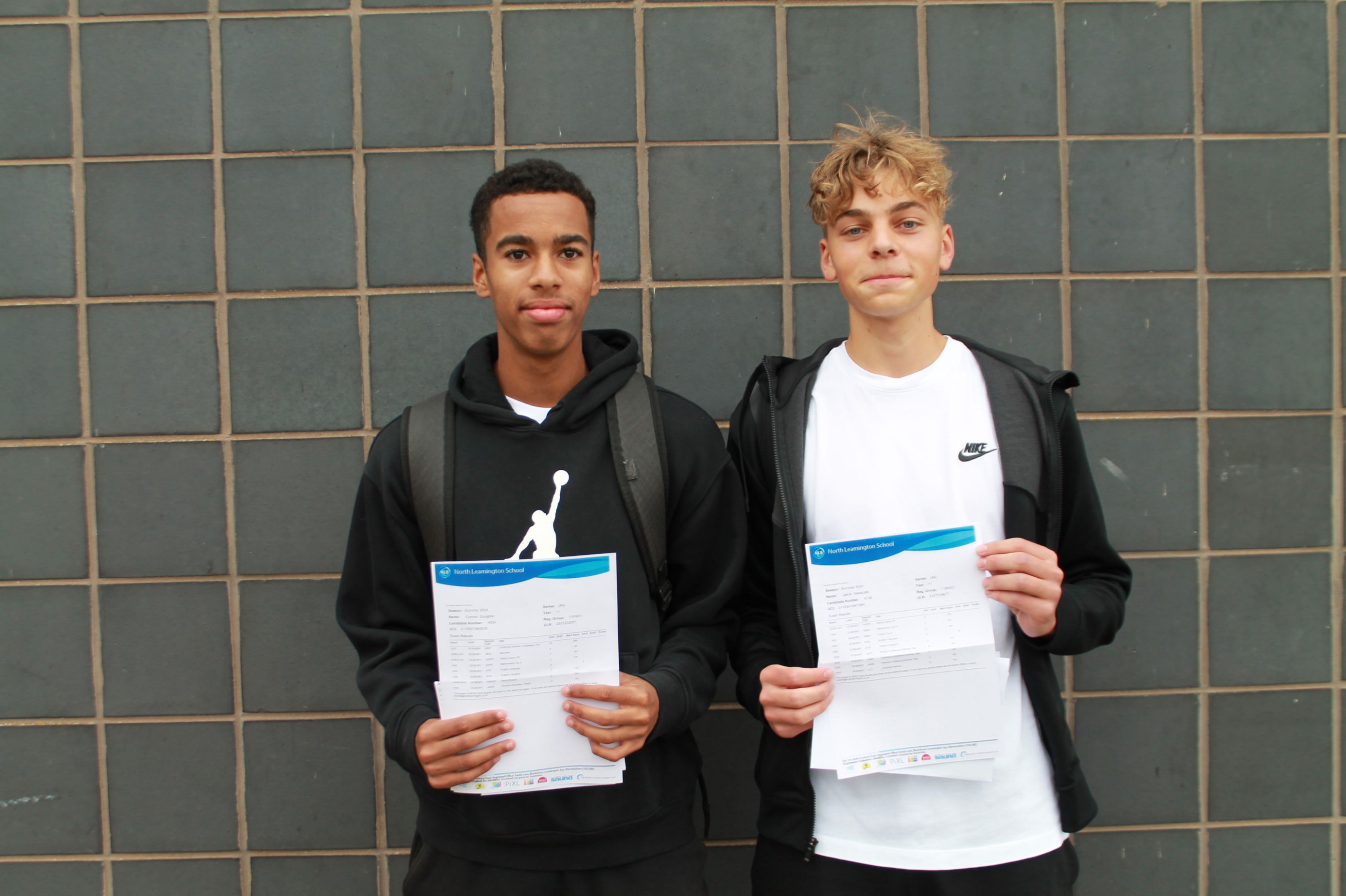 Two students with their GCSE results 