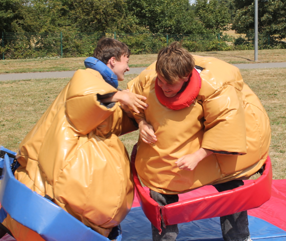 two students enjoying the sumo suits