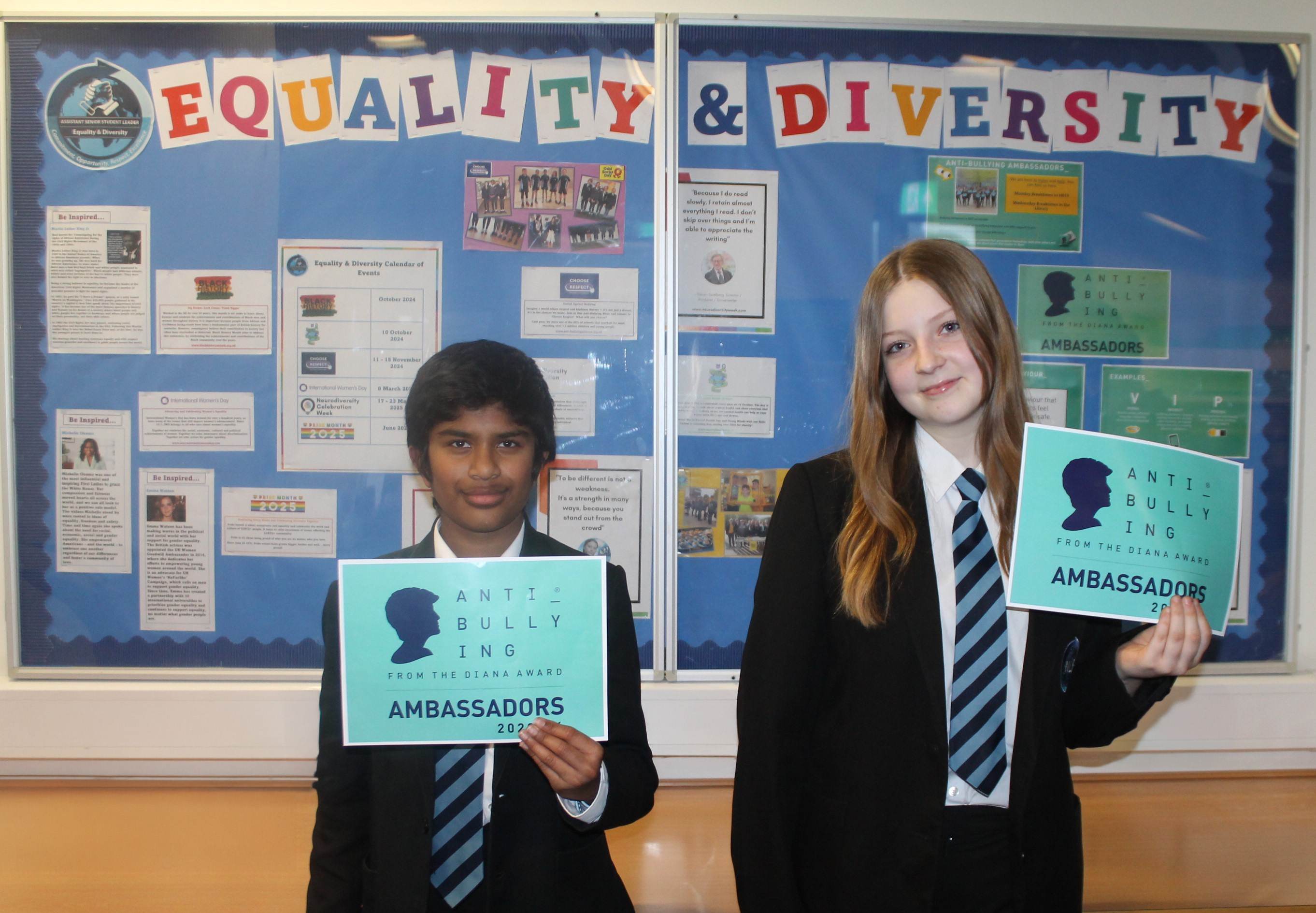 Two Anti-Bullying Ambassador students standing in front of an Equality and Diversity display board