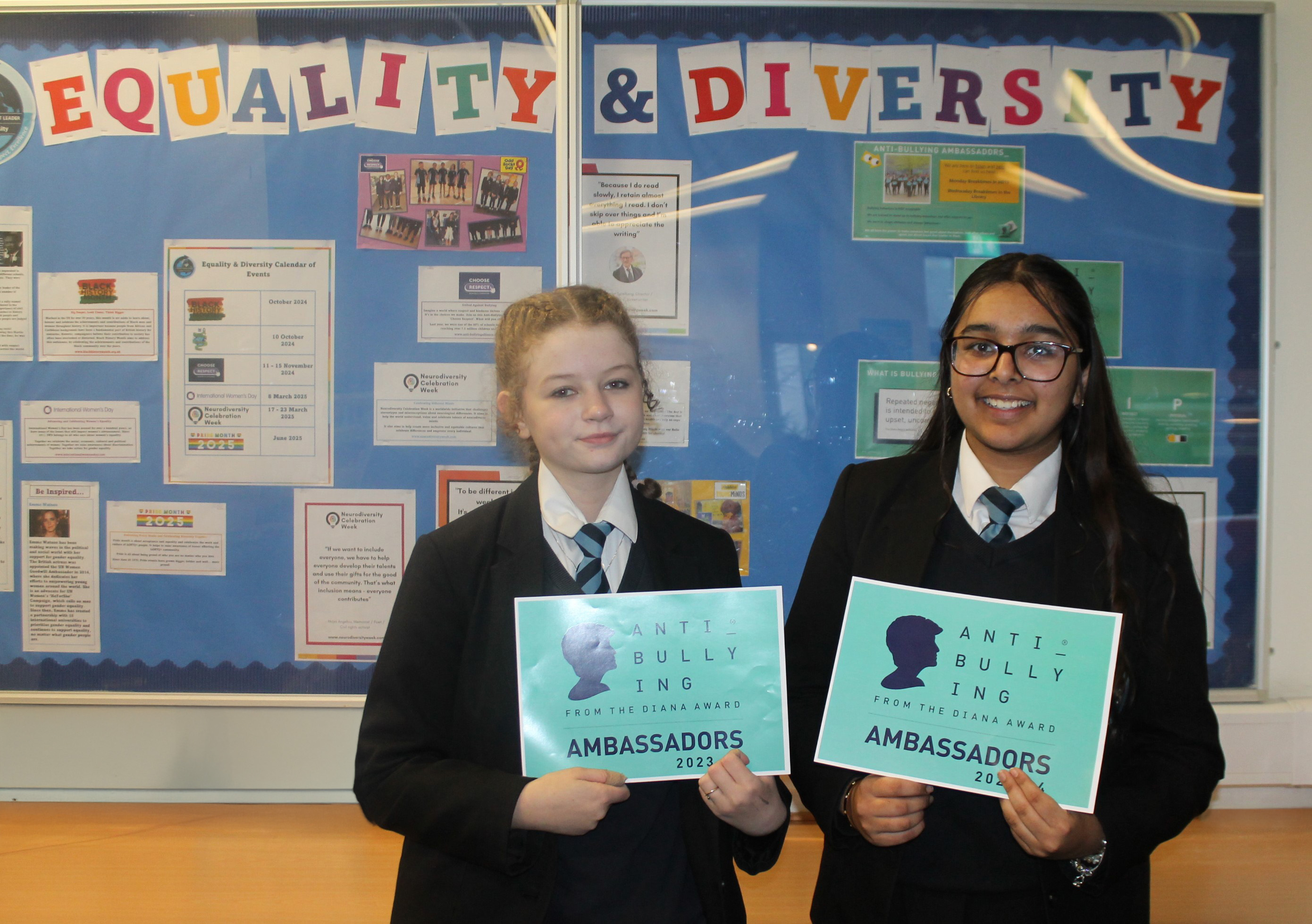 Two Anti-Bullying Ambassador students standing in front of an Equality and Diversity  display board