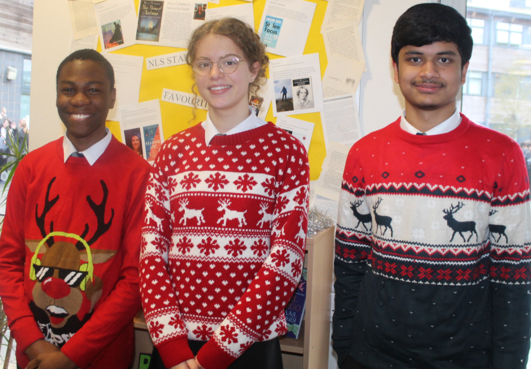 Three students wearing Christmas jumpers