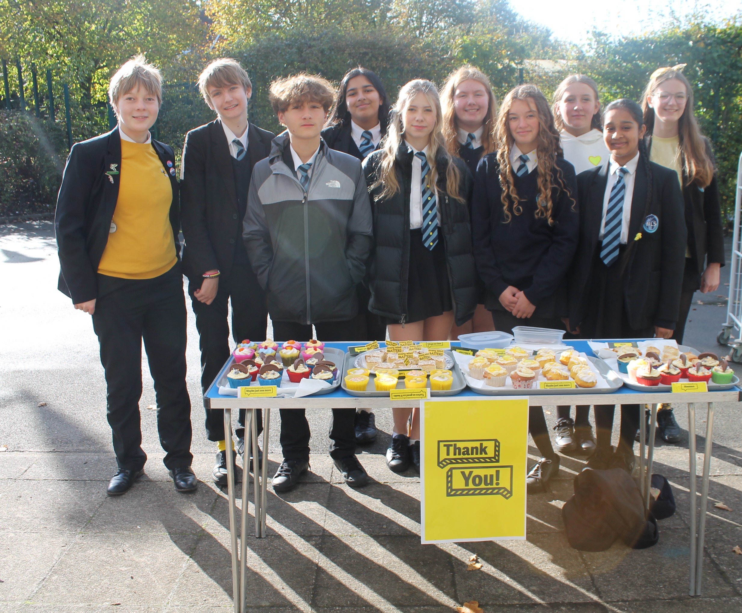 A group of students behind tables selling cakes