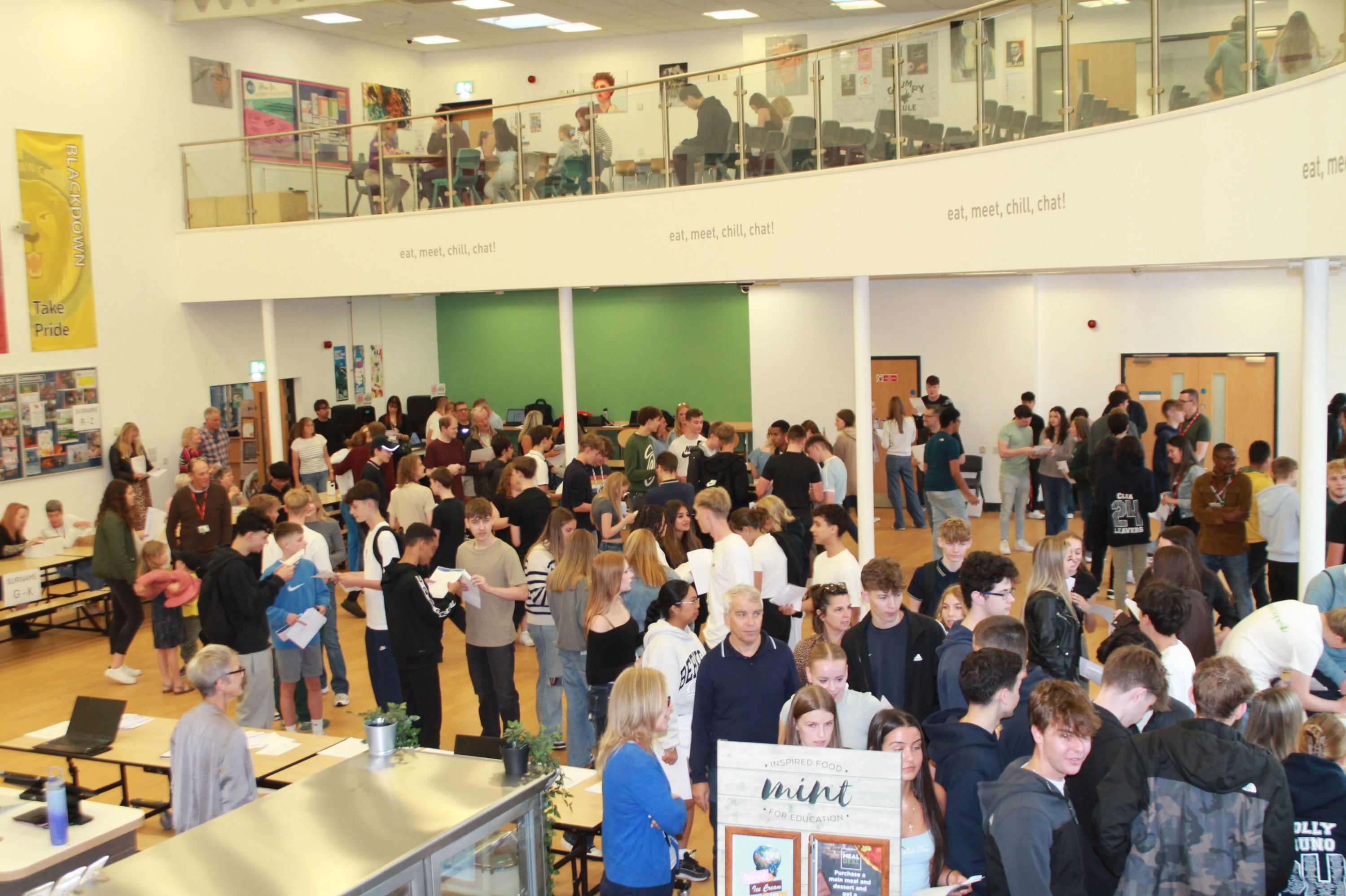 Students collecting and celebrating their GCSE results, on the Mezzanine students are enrolling for Sixth Form  