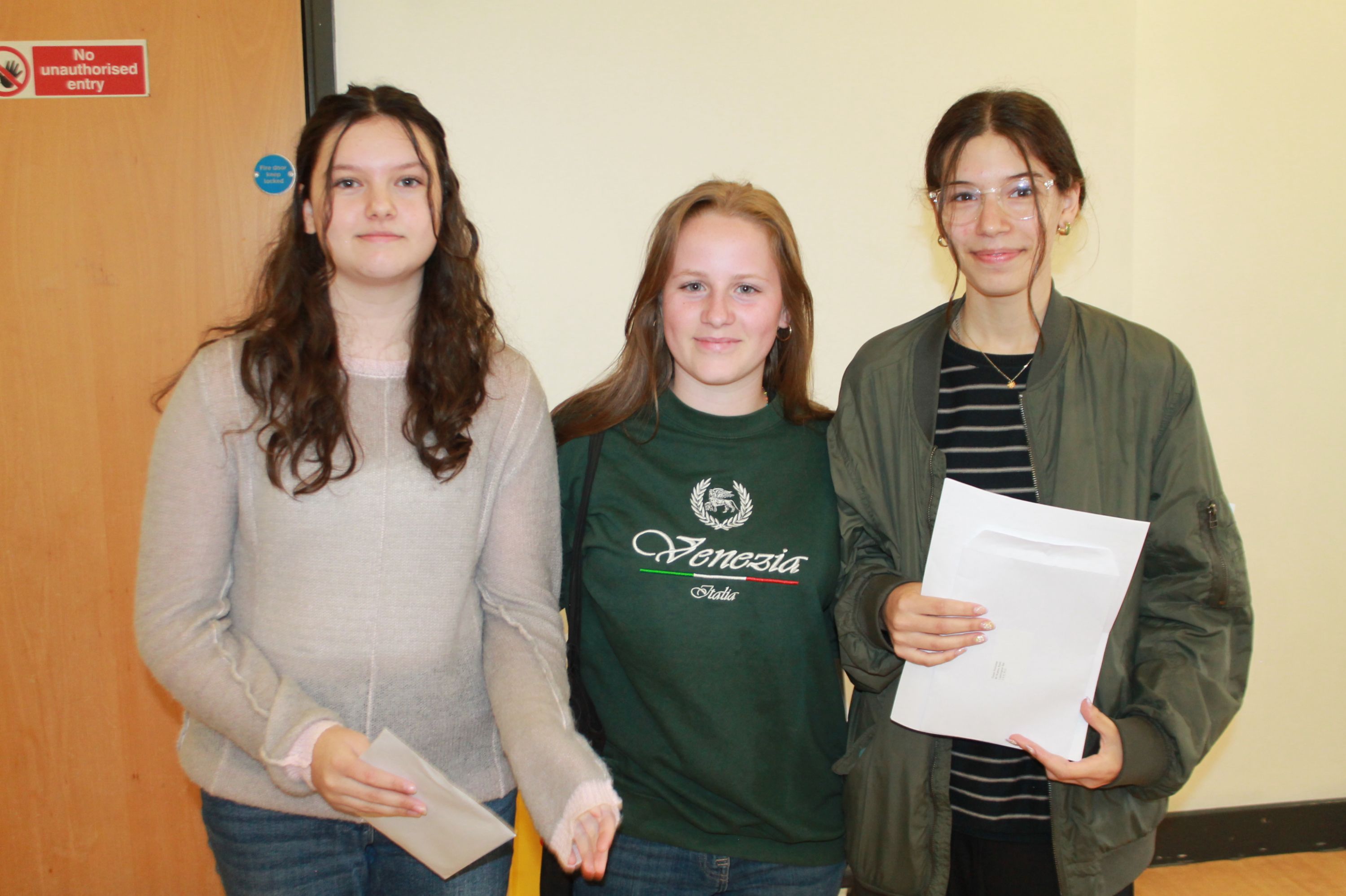 Three students with their GCSE results