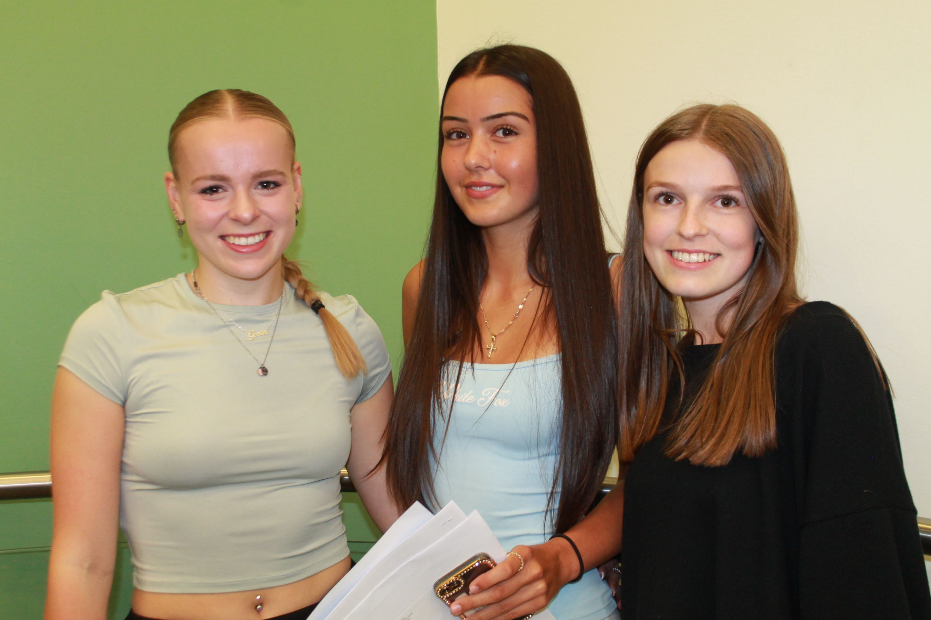 Three students with their GCSE results